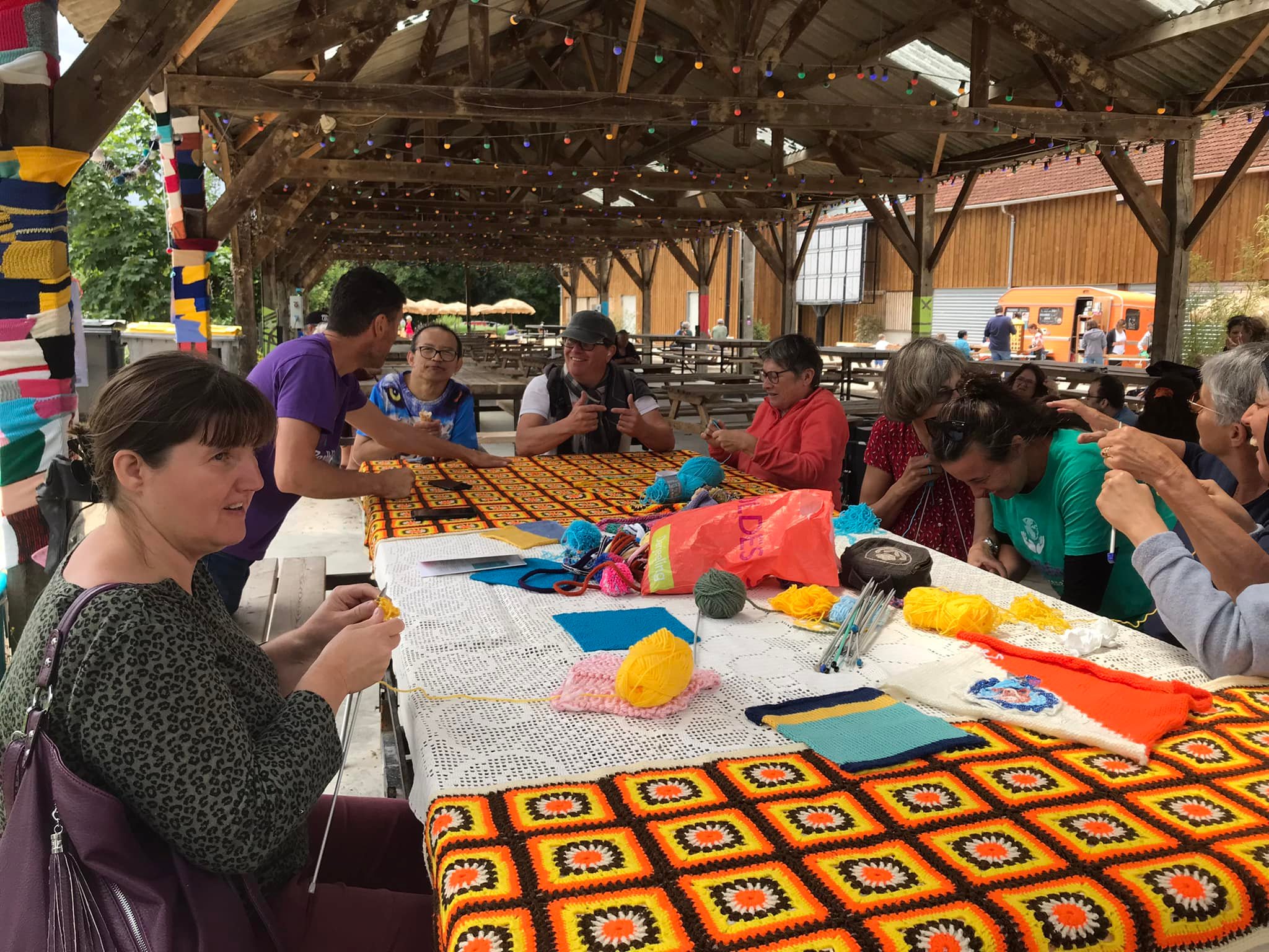 Photo de personnes autour d'une table en train de tricoter